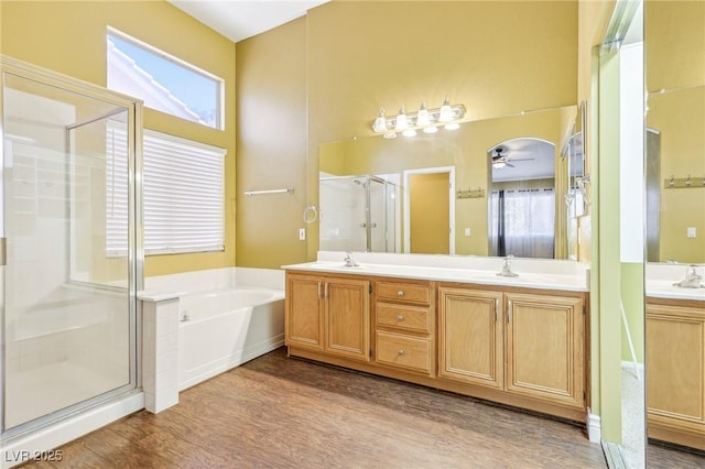 bathroom featuring ceiling fan, hardwood / wood-style floors, vanity, and shower with separate bathtub