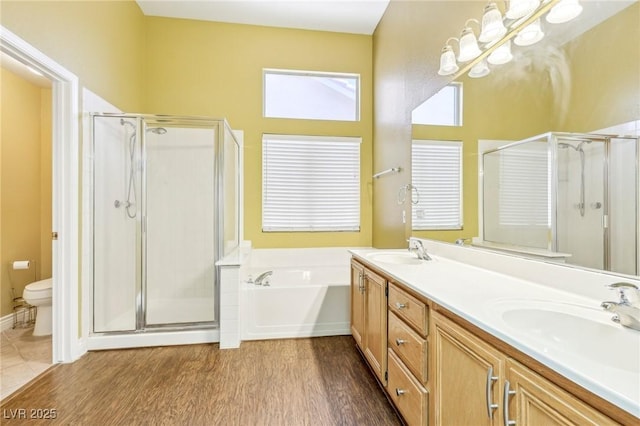 full bathroom with toilet, shower with separate bathtub, wood-type flooring, and vanity