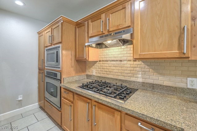 kitchen with stainless steel appliances, light tile patterned floors, and decorative backsplash