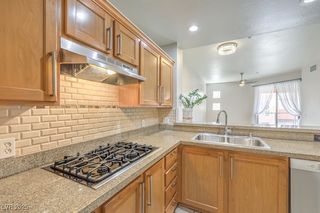 kitchen featuring ceiling fan, stainless steel gas stovetop, dishwashing machine, sink, and backsplash