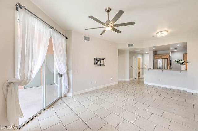 unfurnished living room with ceiling fan and light tile patterned floors