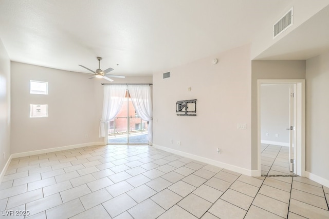 tiled empty room featuring ceiling fan and plenty of natural light