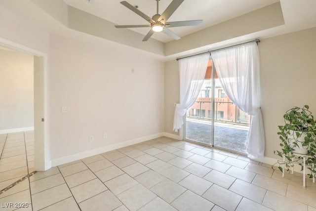 unfurnished room featuring a raised ceiling and light tile patterned floors