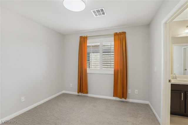 unfurnished room with light colored carpet and sink