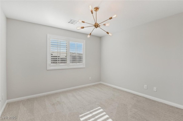 carpeted spare room with a chandelier