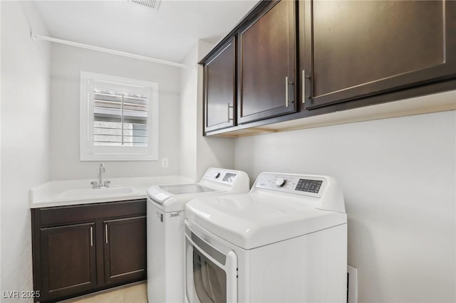 clothes washing area with washing machine and dryer, sink, crown molding, and cabinets