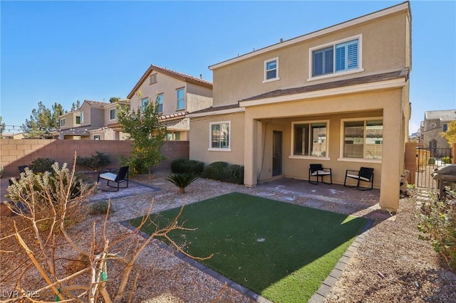 back of house with a patio area and a lawn