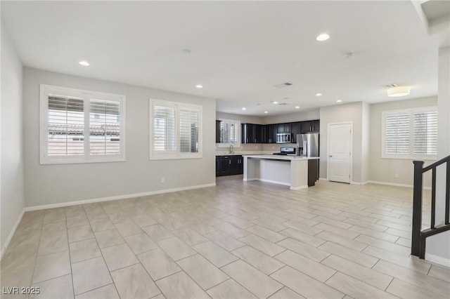 unfurnished living room with a healthy amount of sunlight and sink