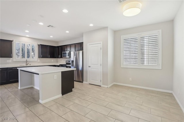 kitchen featuring plenty of natural light, sink, stainless steel appliances, and a center island