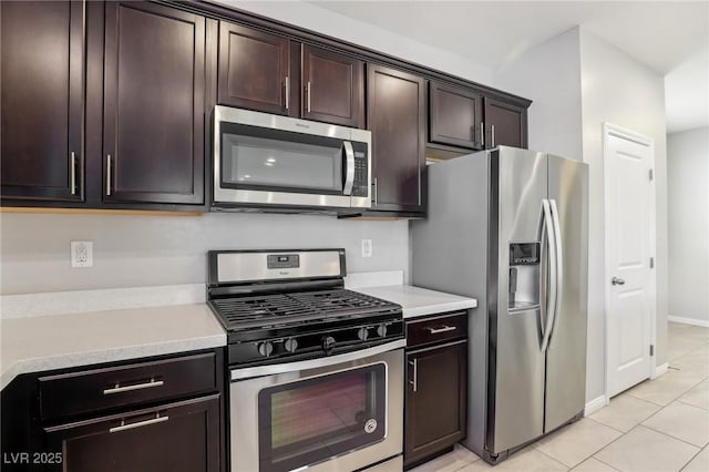 kitchen featuring light tile patterned floors, appliances with stainless steel finishes, and dark brown cabinets