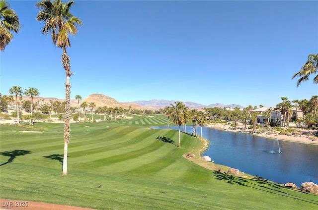 view of home's community featuring a water and mountain view and a yard