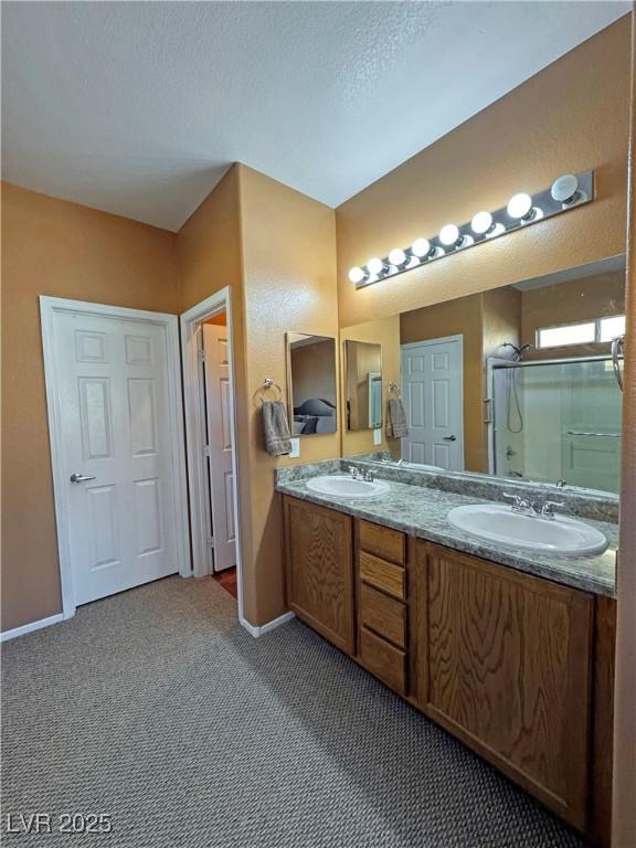 bathroom featuring vanity, a textured ceiling, and walk in shower