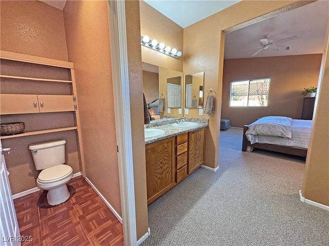 bathroom with toilet, ceiling fan, parquet flooring, and vanity