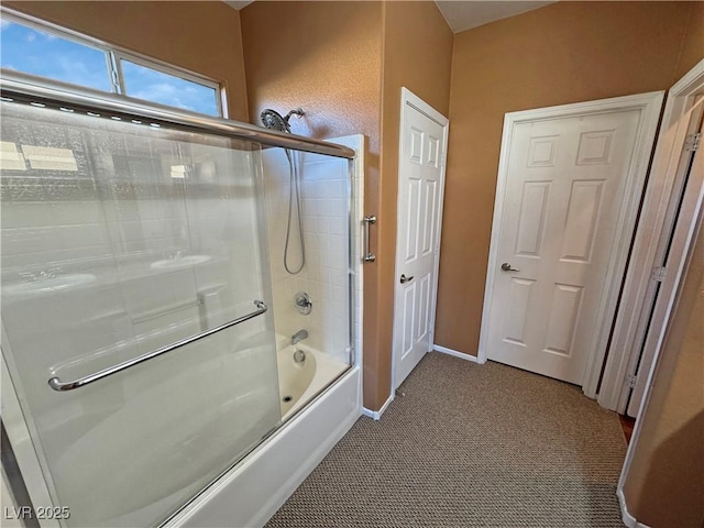 bathroom featuring shower / bath combination with glass door