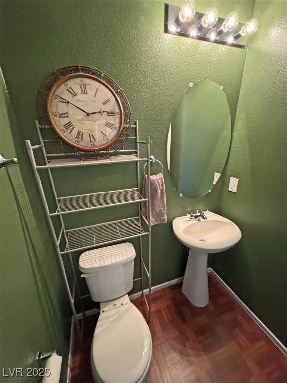 bathroom with toilet and parquet floors