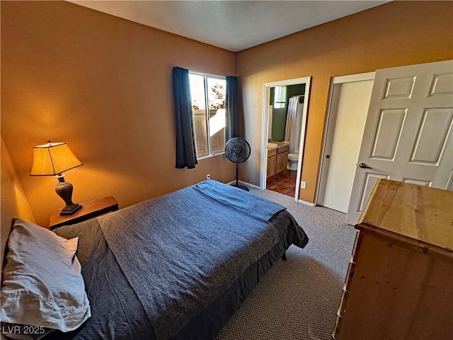 bedroom featuring ensuite bath and carpet floors