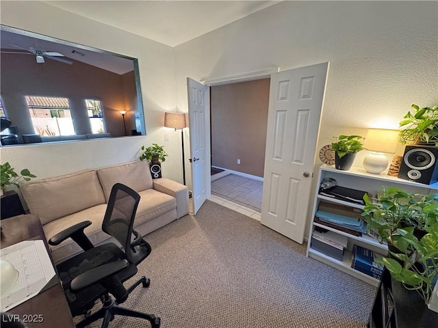 carpeted home office featuring lofted ceiling and ceiling fan