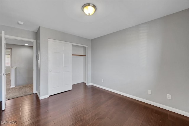 unfurnished bedroom featuring dark wood-type flooring and a closet