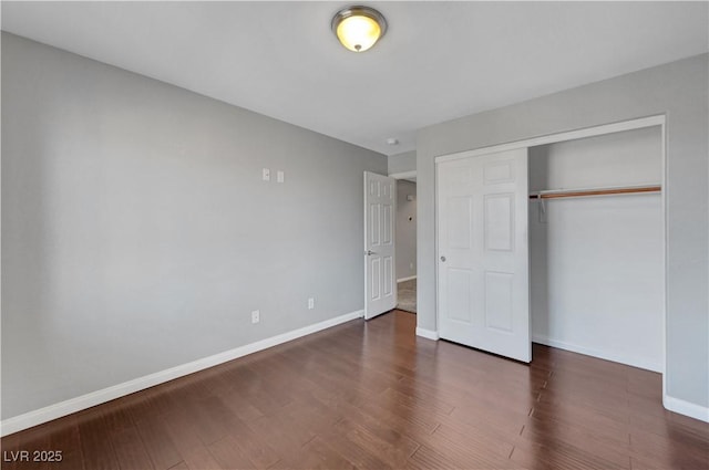 unfurnished bedroom featuring dark wood-type flooring and a closet