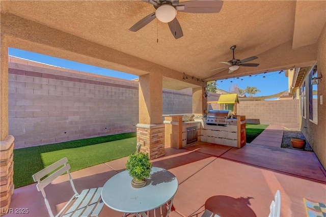 view of patio / terrace featuring an outdoor kitchen, ceiling fan, and a grill