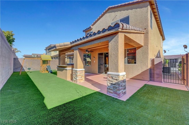 rear view of property featuring a yard, a playground, and a patio area