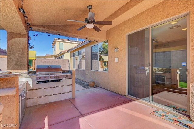 view of patio / terrace featuring exterior kitchen, ceiling fan, and a grill