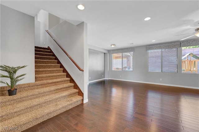 stairway featuring ceiling fan and wood-type flooring