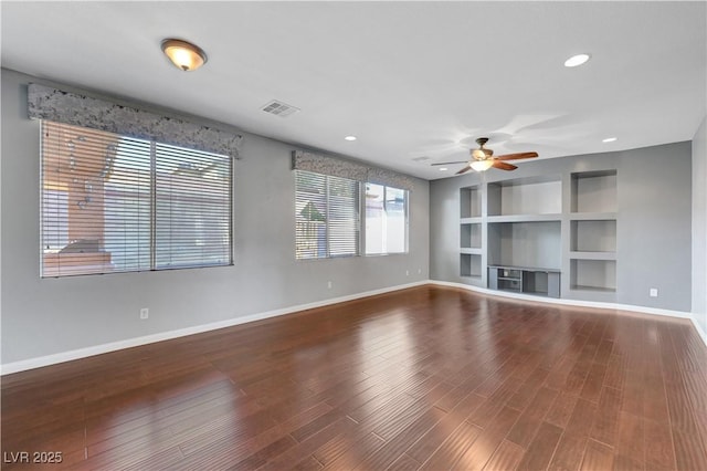 unfurnished living room featuring ceiling fan, built in shelves, and wood-type flooring