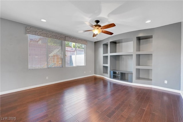 unfurnished living room featuring ceiling fan, built in shelves, and dark wood-type flooring