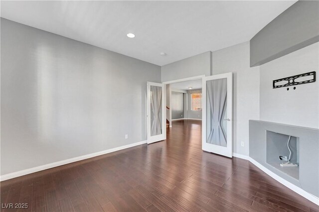 empty room with dark wood-type flooring and french doors