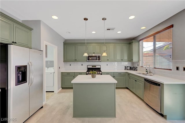 kitchen featuring stainless steel appliances, green cabinetry, and sink