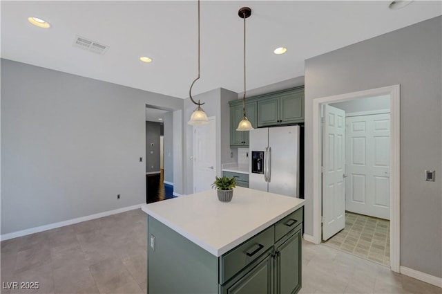 kitchen with stainless steel refrigerator with ice dispenser, a kitchen island, decorative light fixtures, and green cabinetry