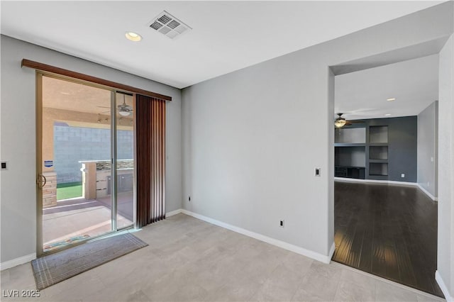 spare room featuring built in features and ceiling fan