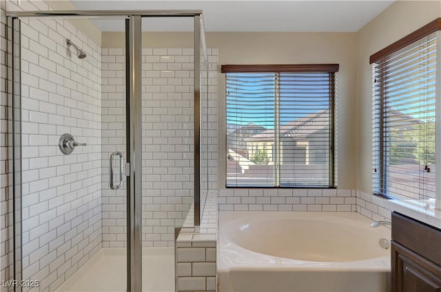 bathroom with a healthy amount of sunlight, separate shower and tub, and vanity