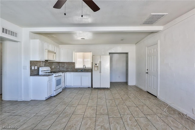 kitchen featuring white appliances, ceiling fan, beam ceiling, white cabinetry, and tasteful backsplash