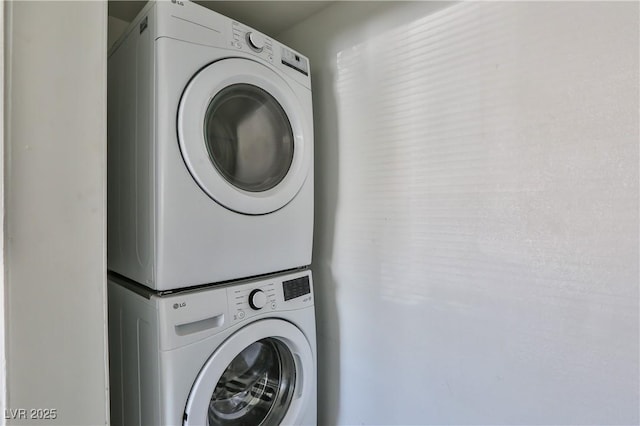 clothes washing area featuring stacked washer and clothes dryer