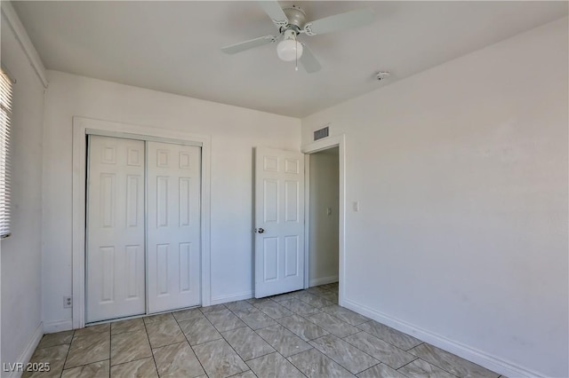 unfurnished bedroom with ceiling fan and a closet