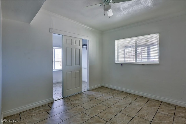 empty room featuring ornamental molding, ceiling fan, and light tile patterned floors