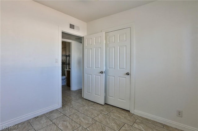 unfurnished bedroom with a closet and light tile patterned floors