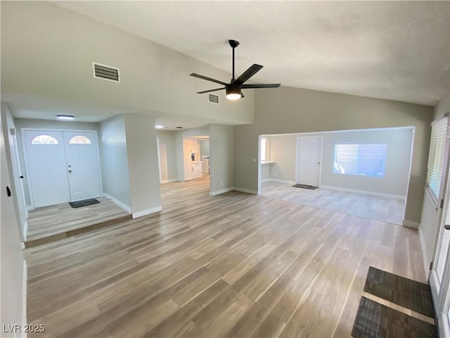 unfurnished living room with lofted ceiling, ceiling fan, and light hardwood / wood-style flooring