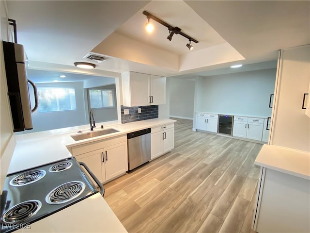 kitchen featuring sink, white cabinets, dishwasher, tasteful backsplash, and wine cooler