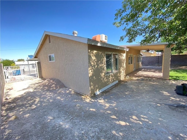 view of side of property with ceiling fan and a patio