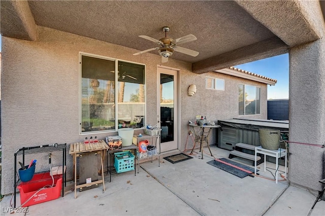 view of patio featuring ceiling fan and a hot tub