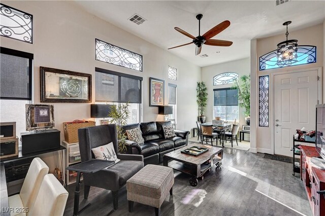 living room with a high ceiling, hardwood / wood-style flooring, and ceiling fan