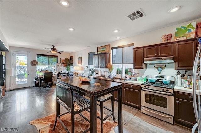 kitchen featuring ceiling fan, stainless steel range with gas cooktop, dark brown cabinetry, sink, and light hardwood / wood-style flooring