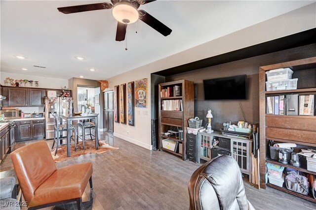 living room featuring light wood-type flooring and ceiling fan