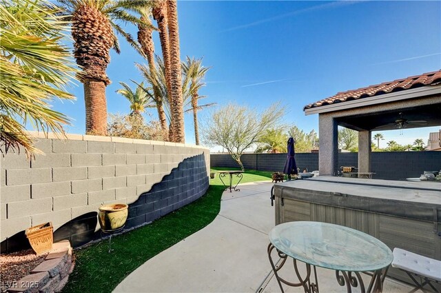 view of patio / terrace with ceiling fan and a hot tub