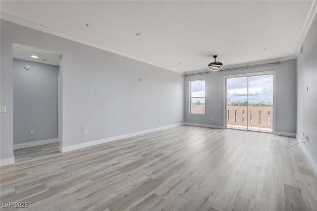 spare room featuring light wood-type flooring and crown molding