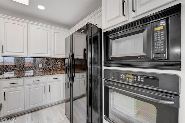 kitchen featuring white cabinets, dark stone countertops, black appliances, and tasteful backsplash