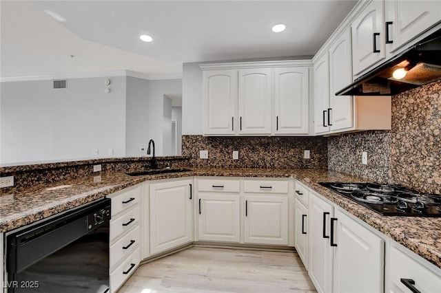 kitchen featuring sink, dark stone counters, black appliances, and white cabinetry